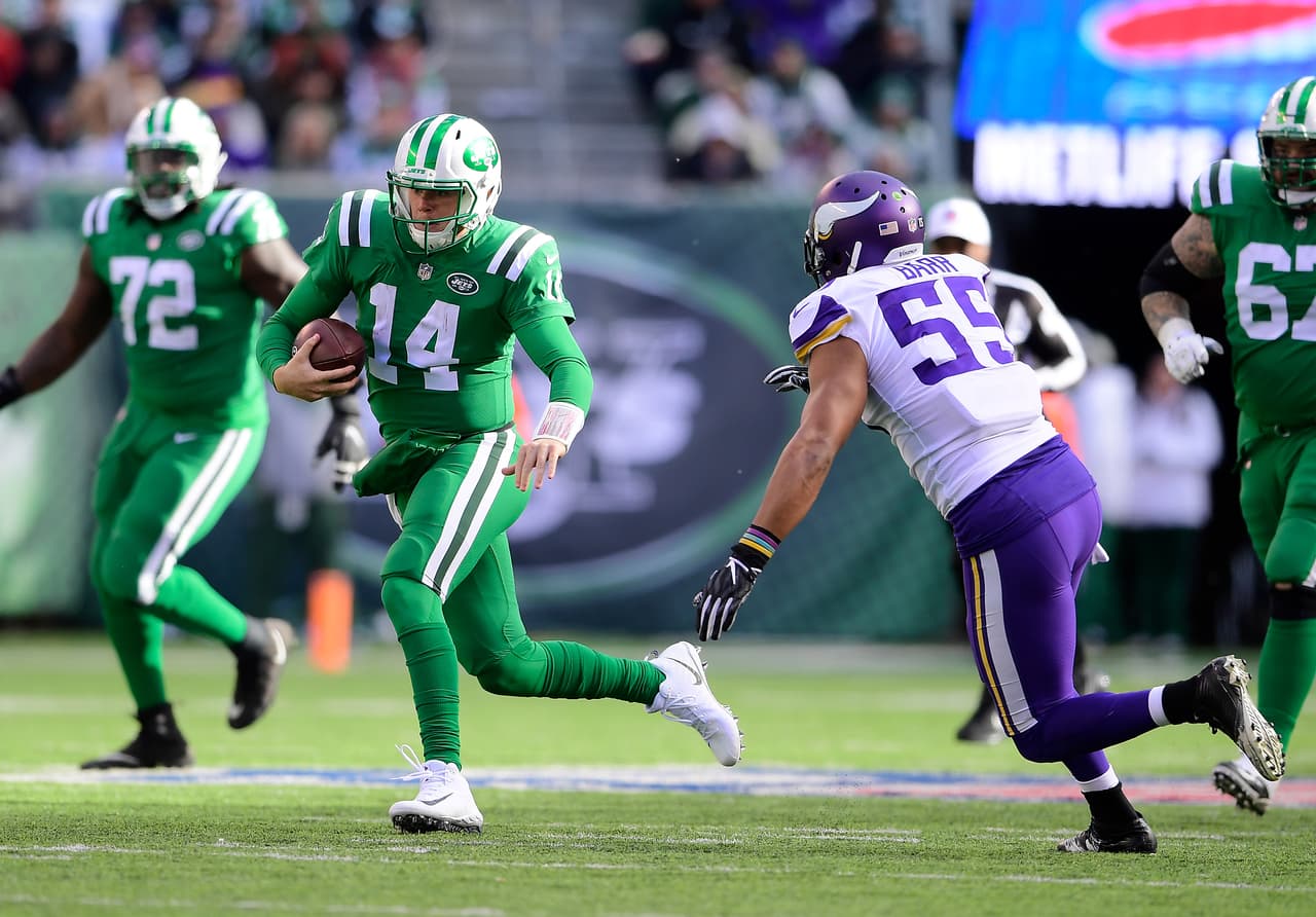 Sam Darnold #14 of the New York Jets is pursued by Anthony Barr #55 of the Minnesota Vikings at MetLife Stadium on October 21, 2018 in East Rutherford, New Jersey. The Vikings defeated the Jets 37-17.