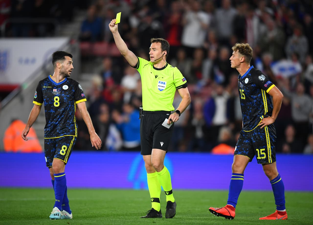 Amarilla para Besar Halimi por reiteración de faltas, el jugador de Kosovo no reclama al ser consciente de sus fallas.