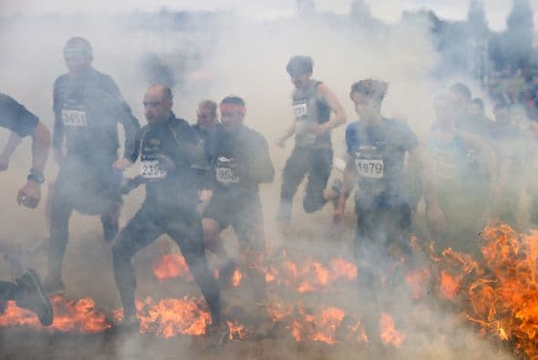 Los deportistas compiten durante el obstáculo fuego de la carrera Tough Viking en Estocolmo. El curso de la carrera Tough Viking consta de 12 kilometros llenos de 15 obstáculos brutales (alambres de púas, barro, hielo, agua, túneles, electricidad, fuego, escalada, etc.) diseñados por especialistas de las Fuerzas Armadas de Suecia.