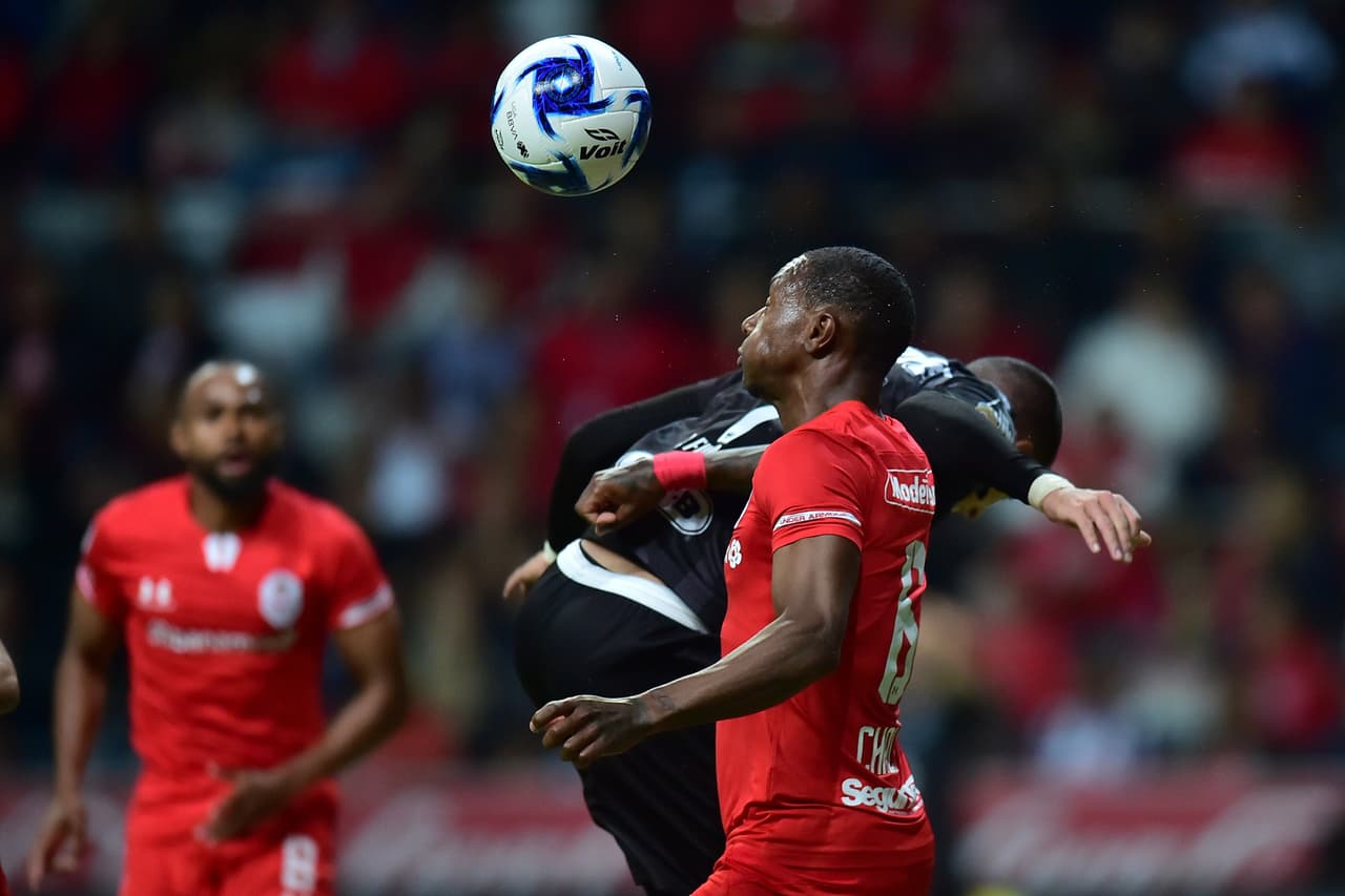 Rogelio Funes Mori no logra contacar el balón y Anibal Chala aleja el peligro de su área.