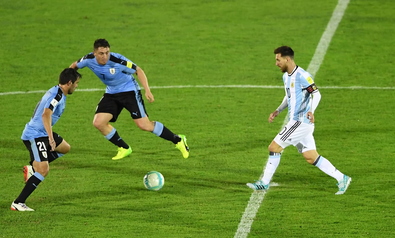 Uruguay's Alvaro Gonzalez (L) and Cristian Rodriguez and Argentina's Lionel Messi (R) eye the ball during their 2018 World Cup qualifier football match in Montevideo, on August 31, 2017. / AFP PHOTO / Pablo PORCIUNCULA BRUNE (Photo credit should read PABLO PORCIUNCULA BRUNE/AFP/Getty Images)