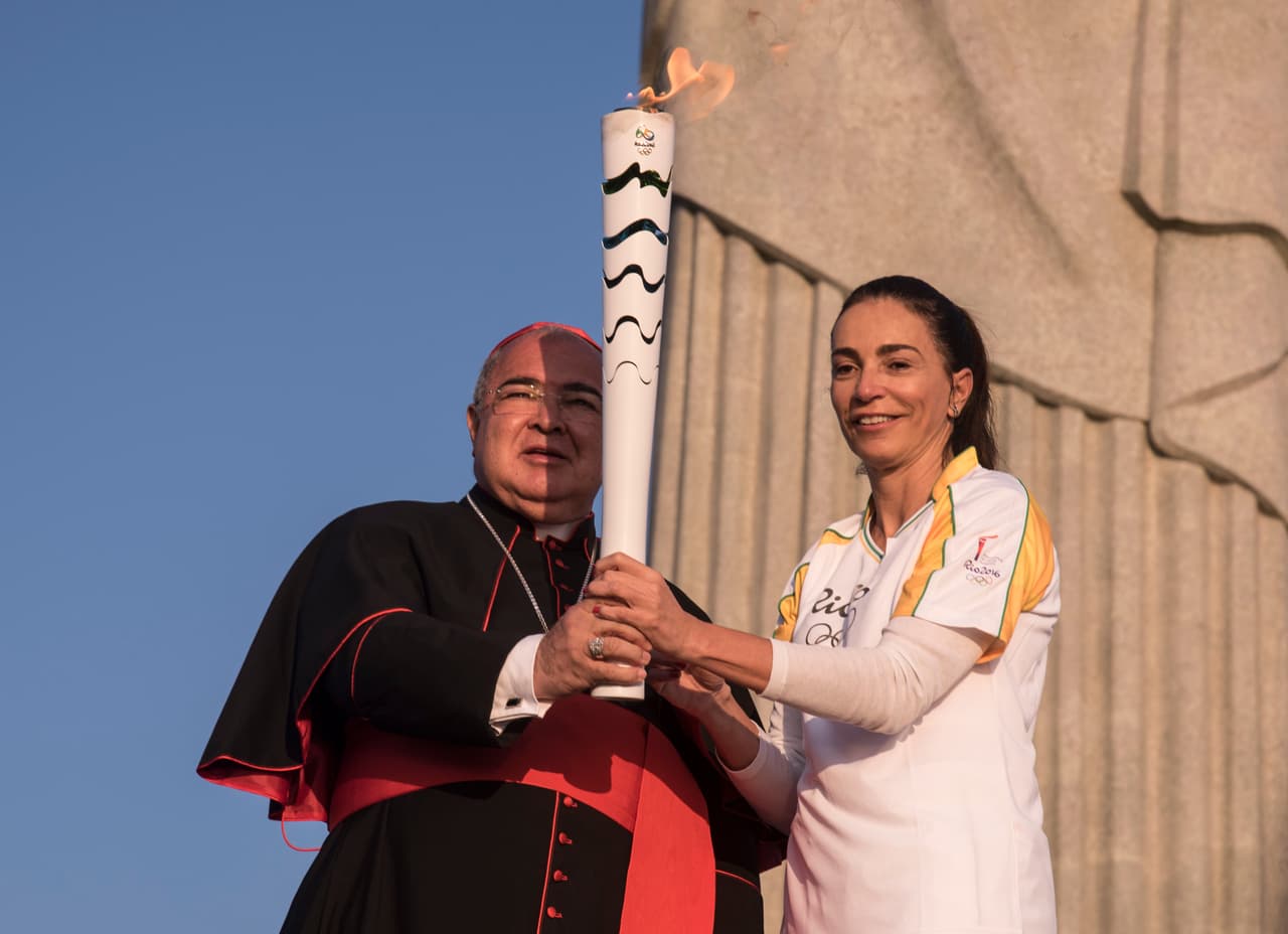 La ex volibolista brasileña Isabel recibe del cardenal Dom Orani la antorcha olímpica para que inicie su último recorrido.