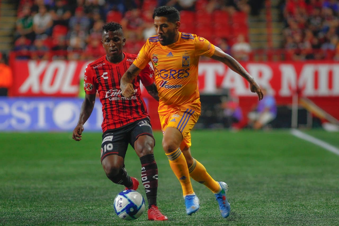 Aquino avanza por la banda, pese a la marca de Miller Bolaños.