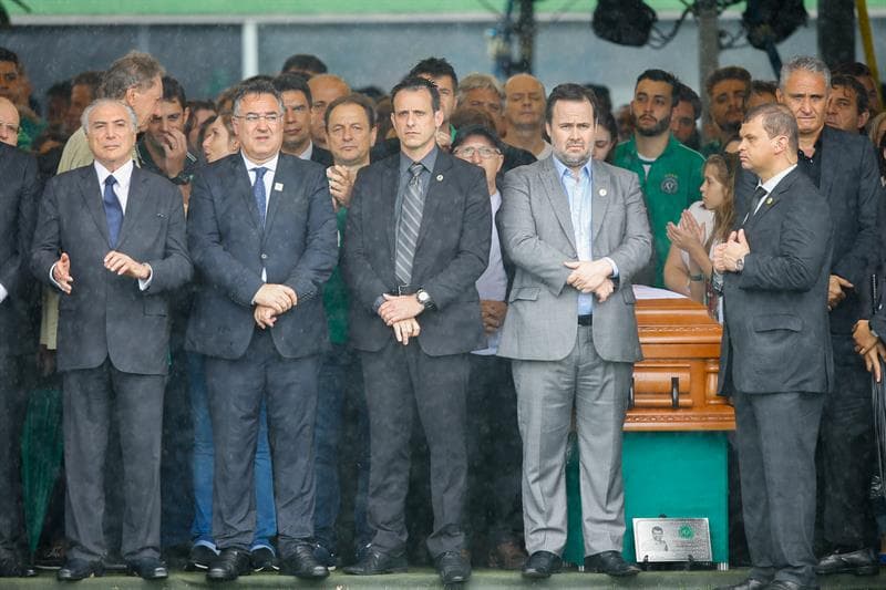 El presidente Michel Temer (i), que decidió a última hora asistir, y el entrenador de la selección brasileña Tite (d) estuvieron junto a féretros de los jugadores y equipo técnico del club brasileño Chapecoense durante el velorio colectivo.