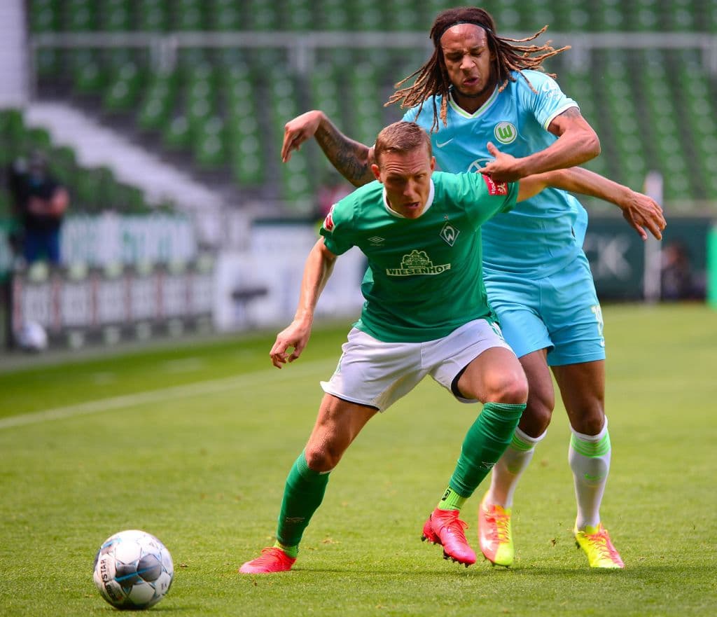 Ludwig Augustinsson y Kevin Mbabu luchan en un costado del campo por la posesión del esférico.