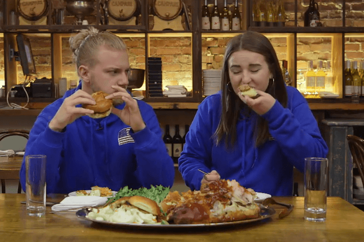 Las tres parejas participantes de la Carrera de la Copa Oro disfrutaron de un platillo típico de Cleveland, una cabeza de cerdo rostizada, en uno de sus retos para ganar el gran premio.