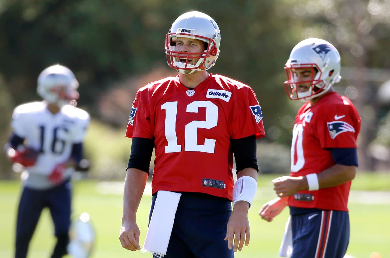 New England Patriots quarterback Tom Brady (12) speaks with teammates while warming up on the field with quarterback Jimmy Garoppolo (10), right, during an NFL football team practice Wednesday, Oct. 5, 2016, in Foxborough, Mass. (AP Photo/Steven Senne)