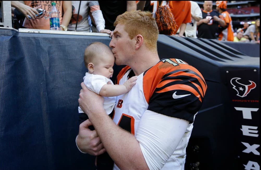 Andy Dalton, quarterback de Cincinnati Bengals, besa a su hijo Noah luego de un partido contra Houston Texans.