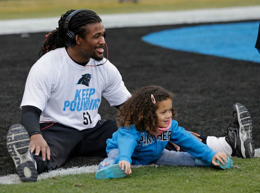 DeAngelo Williams, corredor de Carolina Panthers durante los ejercicios previos a un partido. Su hija Rhiya Williams lo acompaña.
