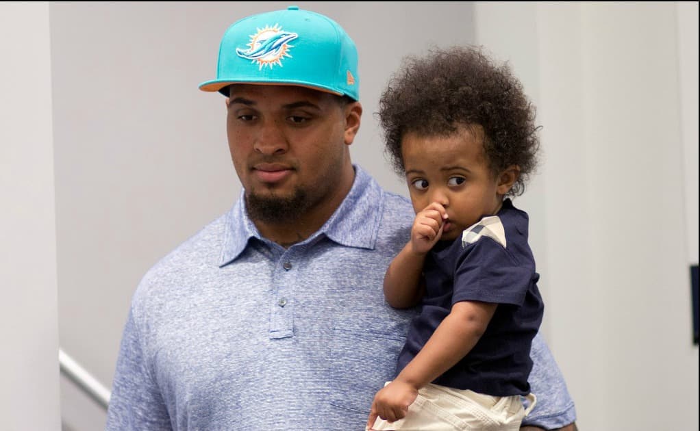 Mike Pouncey, centro de Miami Dolphins, durante el anuncio de extensión de contrato. Bien acompañado por su hijo Kayden.