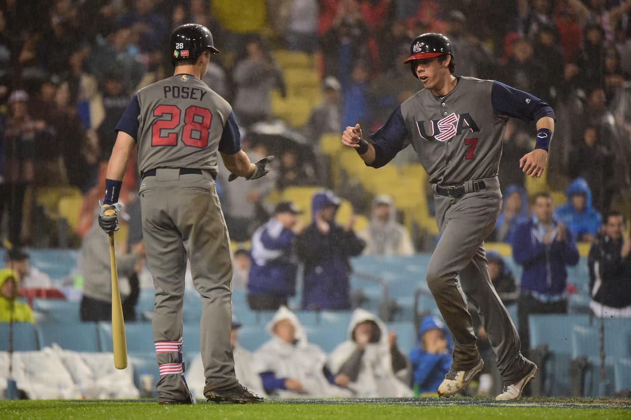 Christian Yelich celebra con Buster Posey tras anotar en la cuarta entrada.