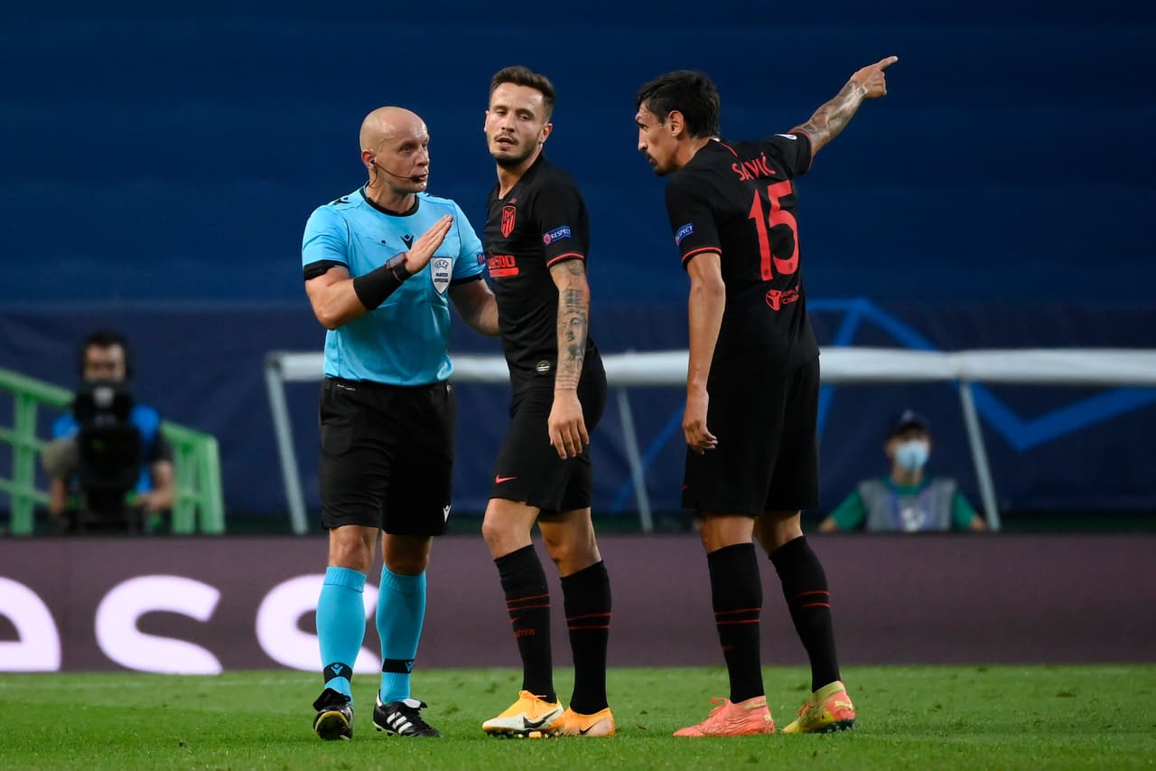 LISBON, PORTUGAL - AUGUST 13: Saul Niguez of Atletico de Madrid and Stefan Savic of Atletico de Madrid confront referee Szymon Marciniak during the UEFA Champions League Quarter Final match between RB Leipzig and Club Atletico de Madrid at Estadio Jose Alvalade on August 13, 2020 in Lisbon, Portugal. (Photo by Lluis Gene/Getty Images)