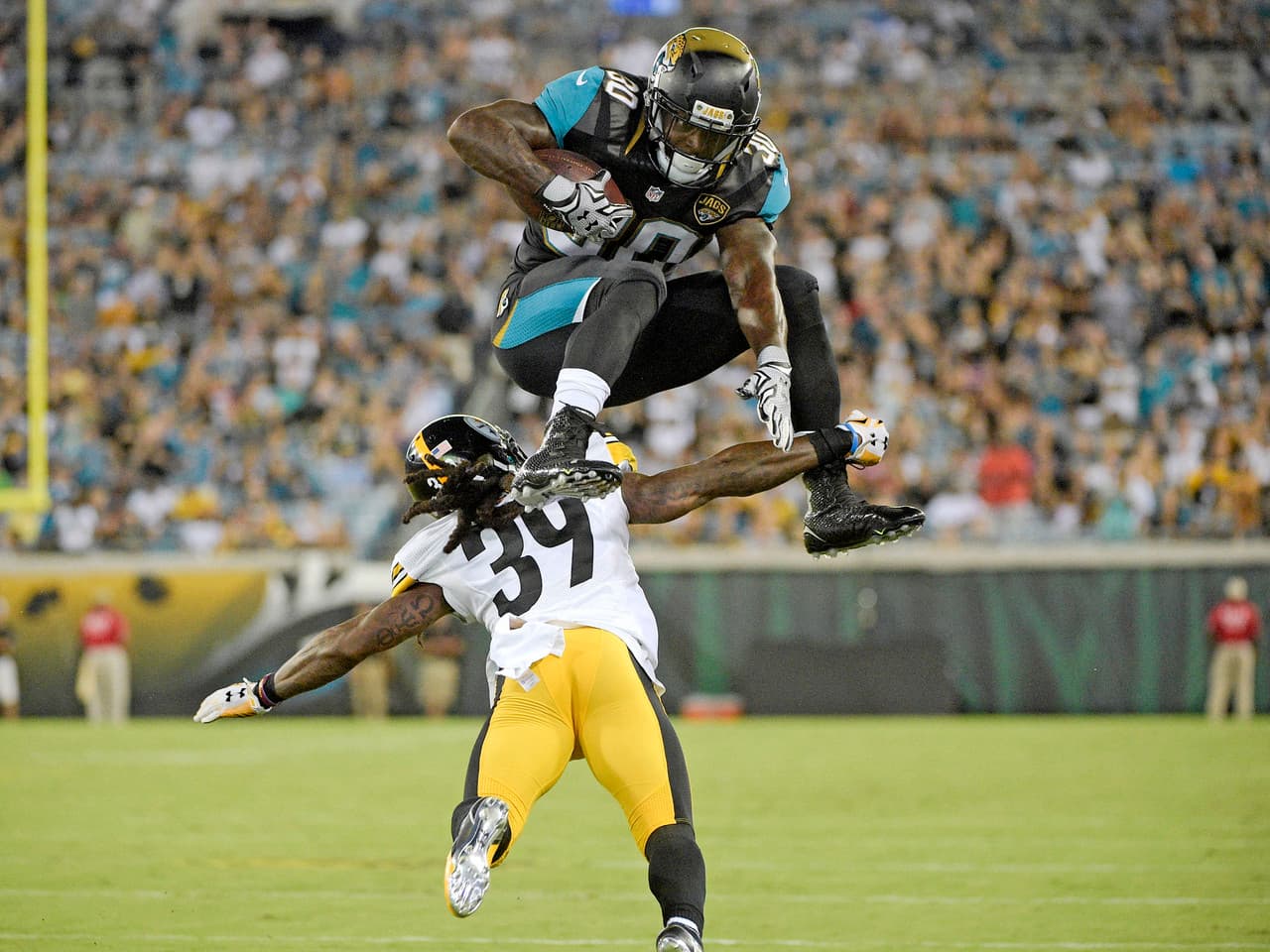 1. EL SALTO DEL JAGUAR: El corredor de los Jacksonville Jaguars, Bernard Pierce (30), saltando sobre el esquinero de los Pittsburgh Steelers, B.W. Webb (39). (AP Photo/Phelan M. Ebenhack)