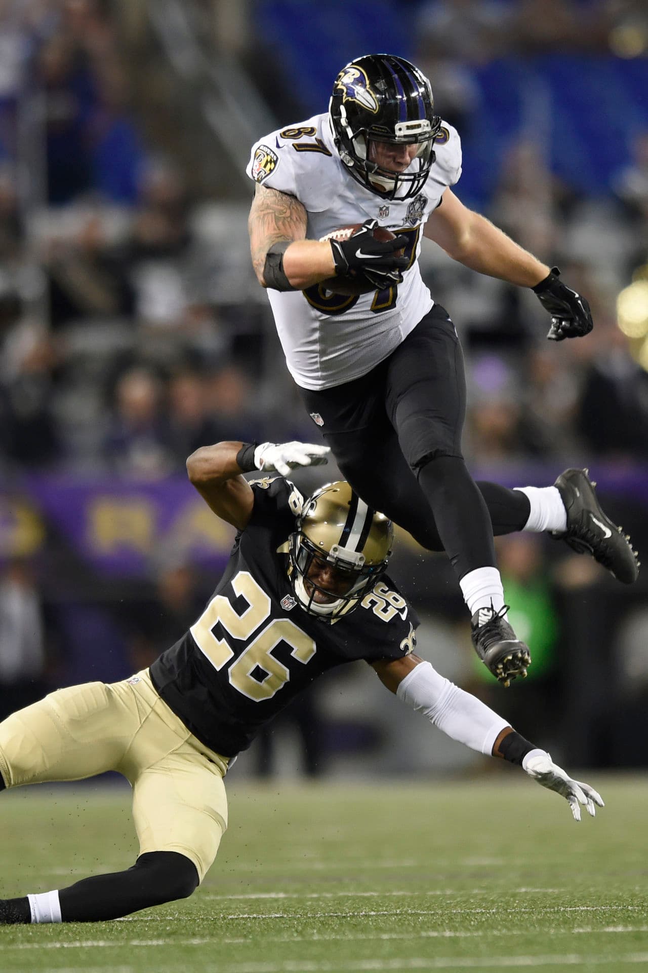 5. CON PERMISO: El ala cerrada de los Baltimore Ravens, Maxx Williams (87), saltó por encima del esquinero de los New Orleans Saints, Travis Manning (26), logrando esquivarlo. (AP Photo/Gail Burton)