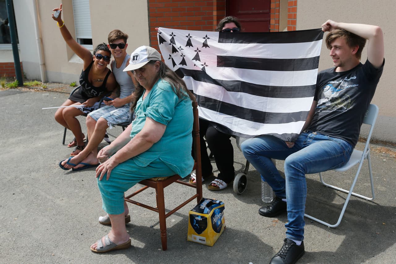 Algunos aficionados al lado del camino de ruta en la región de Bretaña, y es precisamente el lábaro de ese departamento francés el que sostienen estos alegres seguidores.