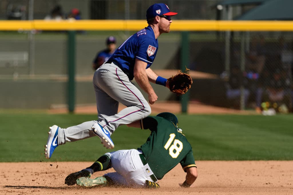 La supervivencia. Logan Forsythe de los Texas Rangers tira a la inicial para convertir un doble play mientras Chad Pinder de los Oakland Athletics se barre para intentar romper la jugada, pero no lo logró, aunque la postal es beisbolera y bella.