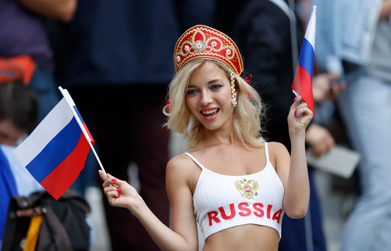 A Russian fan poses for the cameras as she gets ready to cheer on their side as they pose a photograph before the start of the group A match between Russia and Saudi Arabia which opens the 2018 soccer World Cup at the Luzhniki stadium in Moscow, Russia, Thursday, June 14, 2018. (AP Photo/Antonio Calanni)