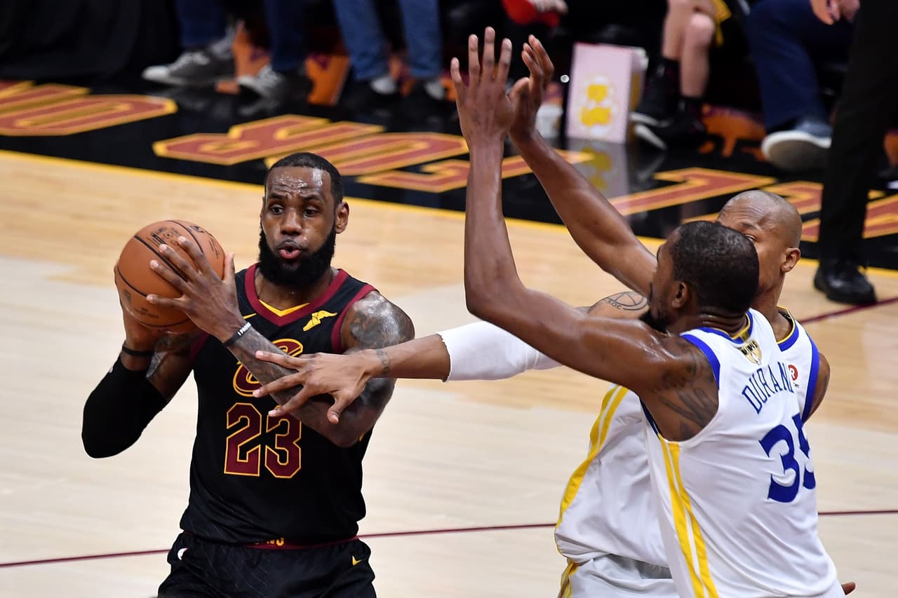CLEVELAND, OH - JUNE 06: LeBron James #23 of the Cleveland Cavaliers drives to the basket defended by Kevin Durant #35 and David West #3 of the Golden State Warriors in the first half during Game Three of the 2018 NBA Finals at Quicken Loans Arena on June 6, 2018 in Cleveland, Ohio. NOTE TO USER: User expressly acknowledges and agrees that, by downloading and or using this photograph, User is consenting to the terms and conditions of the Getty Images License Agreement. (Photo by Jamie Sabau/Getty Images)