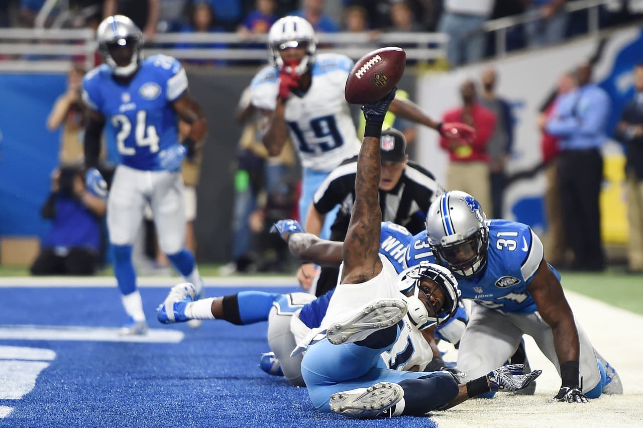 Andre Johnson de los Tennessee Titans atrapó este ovoide en la zona de anotación ante la presión de la defensiva de los Detroit Lions.