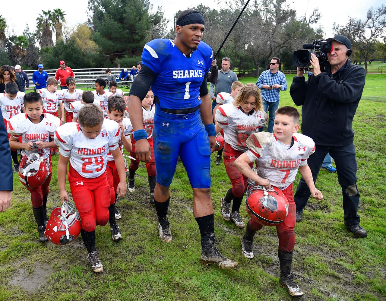 This Jan. 13, 2017 photo shows NFL player Cam Newton, center, tossing a football to youth football players during a break in the filming of a Buick commercial for this year's Super Bowl telecast in Los Angeles. The commercial is set to air during the first quarter. (Photo by Chris Pizzello/Invision/AP)