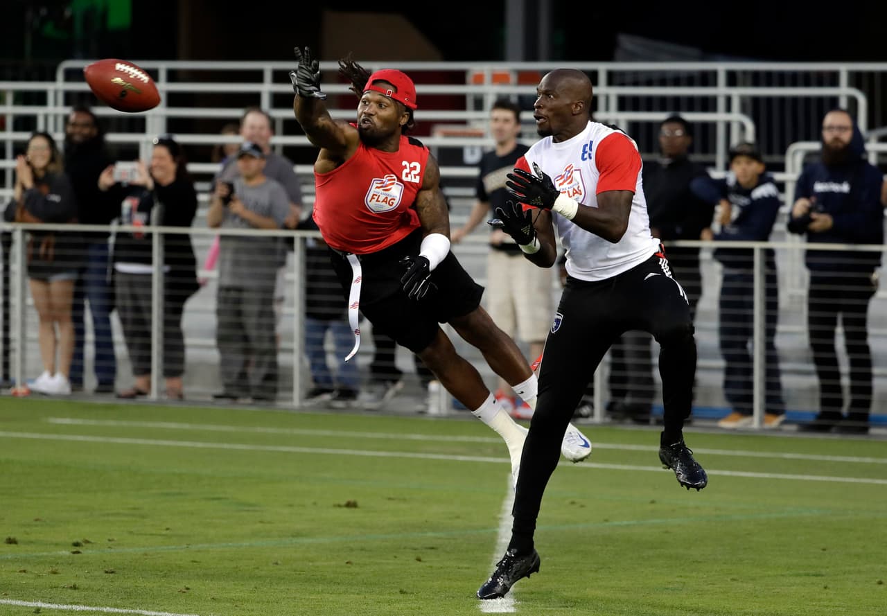 Team Owens' Omar Bolden, left, breaks up a pass intended for Team Vick's Chad Ochocinco during a flag football exhibition game Tuesday, June 27, 2017, in San Jose, Calif. (AP Photo/Marcio Jose Sanchez)