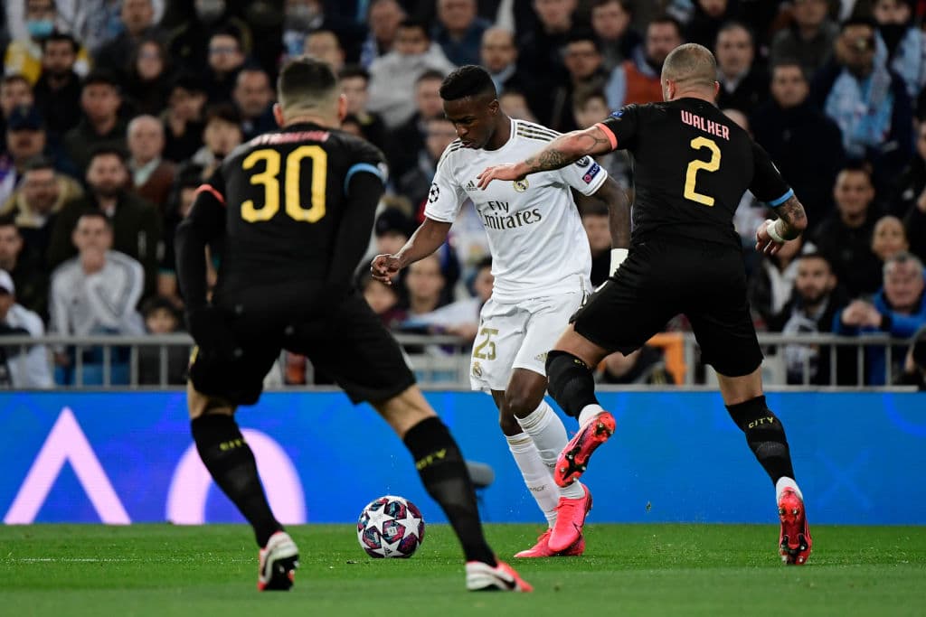 Los jugadores del Manchester City le cierran todos los espacios a Vinícius Júnior por lo que este descarga el balón con Federico Valverde.