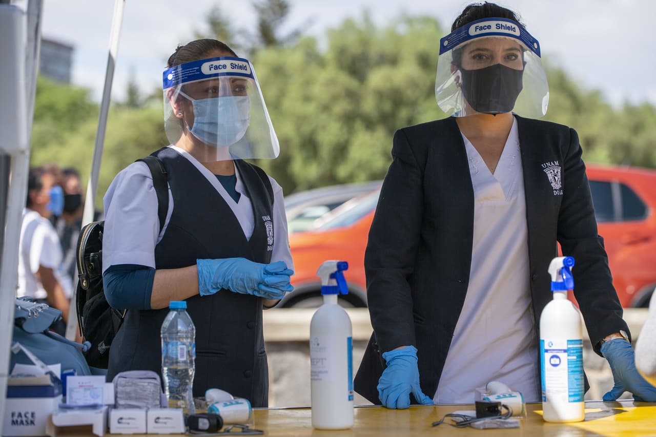 Personal calificado supervisa la entrada de los pocos limitados asistentes al Olímpico Universitario.