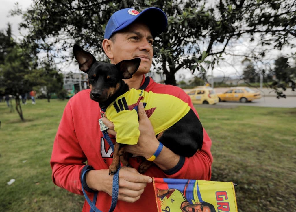 A man waits in the streets of Bogota near the airport to catch a glimpse of the players of the Colombian national team on their way to the El Campin stadium for a welcoming ceremony after their participation in the FIFA World Cup, on July 5, 2018. (Photo by John VIZCAINO / AFP) (Photo credit should read JOHN VIZCAINO/AFP/Getty Images)