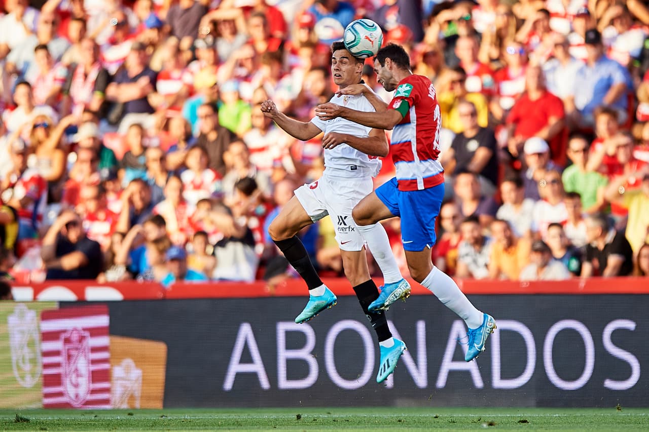 GRANADA, SPAIN - AUGUST 23: Victor Diaz of Granada CF competes for the ball with Sergio Reguilon of Sevilla FC during the Liga match between Granada CF and Sevilla FC at Estadio Nuevo Los Carmenes on August 23, 2019 in Granada, Spain. (Photo by Quality Sport Images/Getty Images)