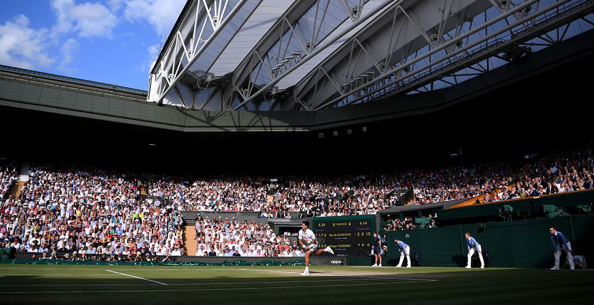 Novak Djokovic realiza un servicio en la cancha histórica de Wimbledon que este año puede no celebrarse por la contingencia del coronavirus.