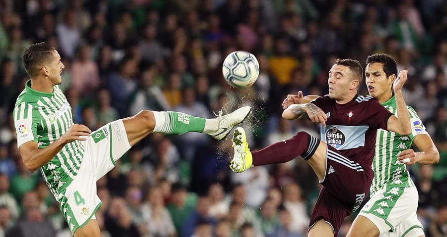 Iago Aspas lucha con Feddal por el balón; el del Betis llega primero y se queda la esférica.