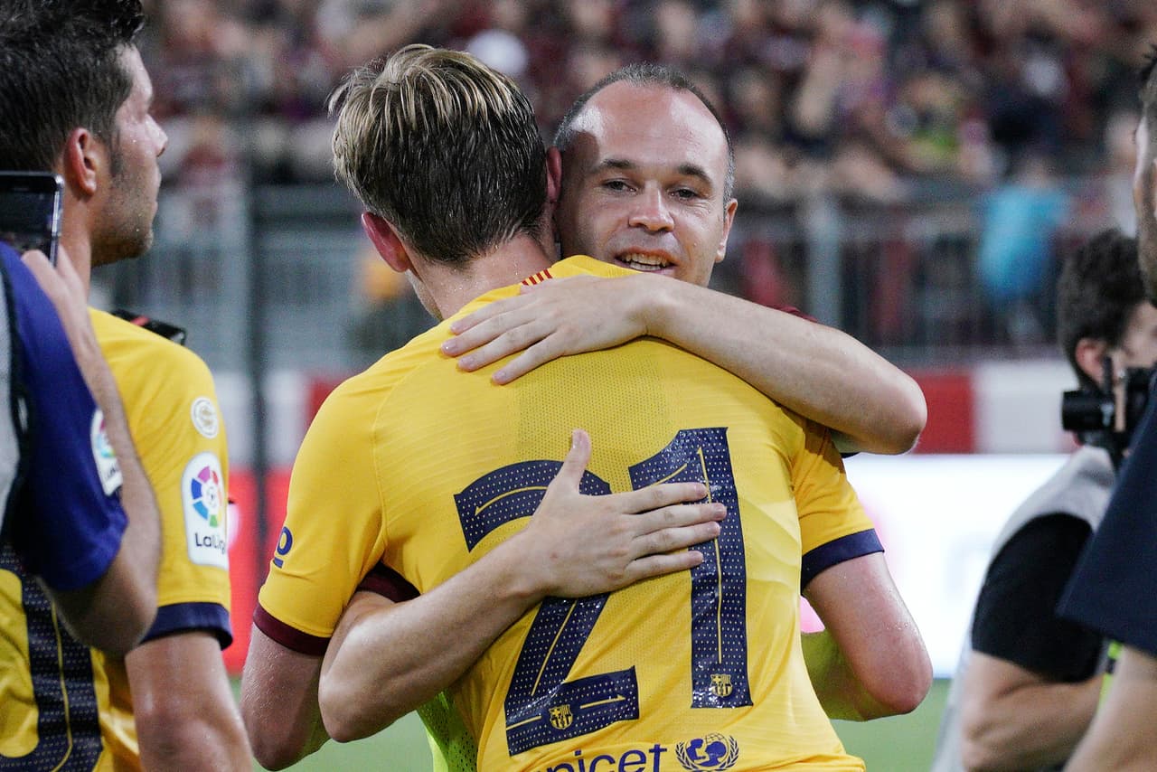 Andrés Iniesta, leyenda del Barcelona, abraza a Frenkie De Jong, reciente adquisición para el centro del campo.