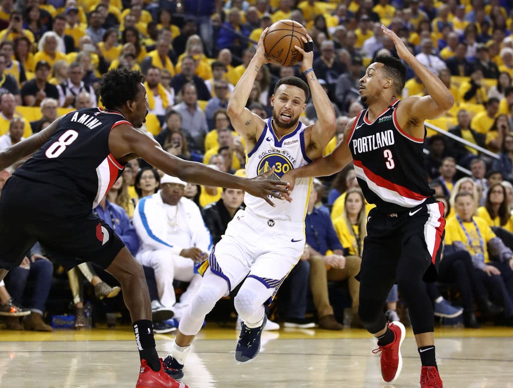 OAKLAND, CALIFORNIA - MAY 14: Stephen Curry #30 of the Golden State Warriors drives to the basket against Al-Farouq Aminu #8 and CJ McCollum #3 of the Portland Trail Blazers during the first half in game one of the NBA Western Conference Finals at ORACLE Arena on May 14, 2019 in Oakland, California. NOTE TO USER: User expressly acknowledges and agrees that, by downloading and or using this photograph, User is consenting to the terms and conditions of the Getty Images License Agreement. (Photo by Ezra Shaw/Getty Images)