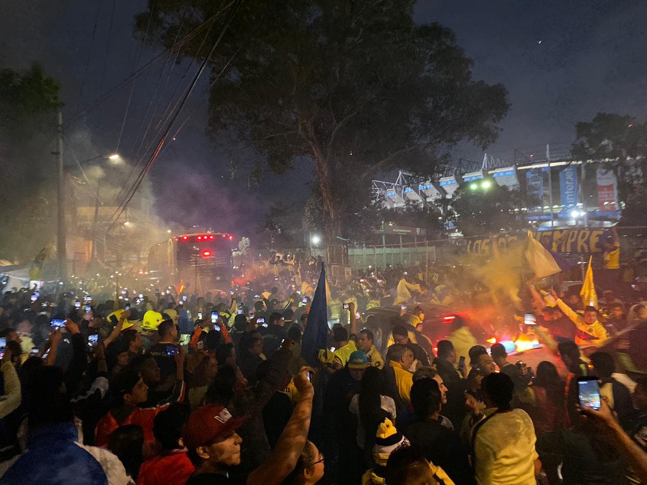 ¡Gran recibimiento al América! La afición le muestra el apoyo a su equipo con cantos, banderas y bengalas a su llegada al Estadio Azteca.