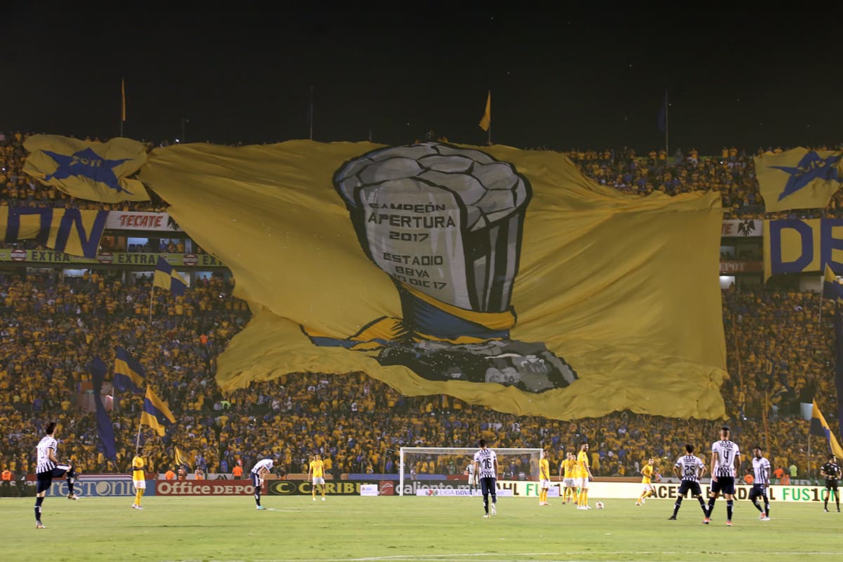 Los fanáticos de Tigres exhibiendo una gran bandera durante el partido.
