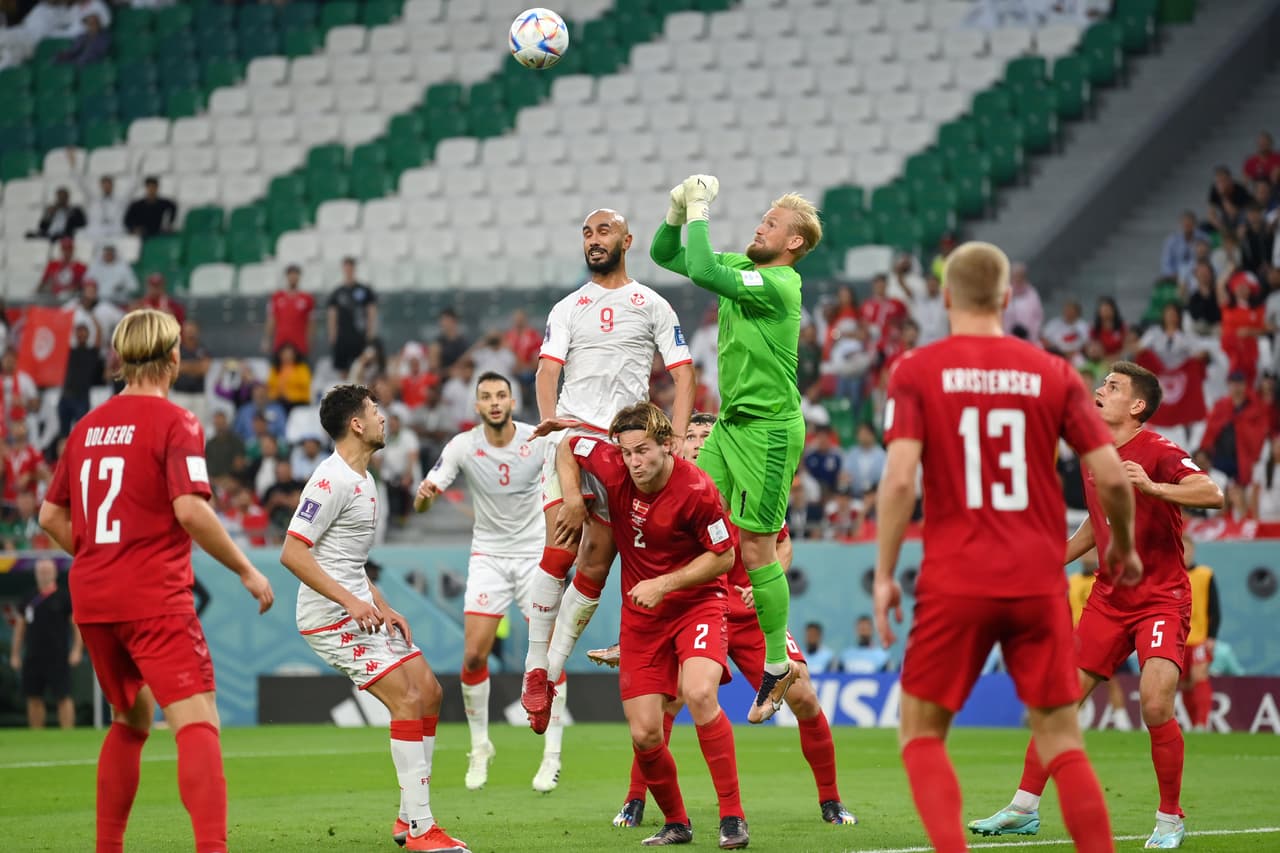AL RAYYAN, QATAR - NOVEMBER 22: Issam Jebali of Tunisia and Kasper Schmeichel of Denmark battle for the ball during the FIFA World Cup Qatar 2022 Group D match between Denmark and Tunisia at Education City Stadium on November 22, 2022 in Al Rayyan, Qatar. (Photo by Justin Setterfield/Getty Images)