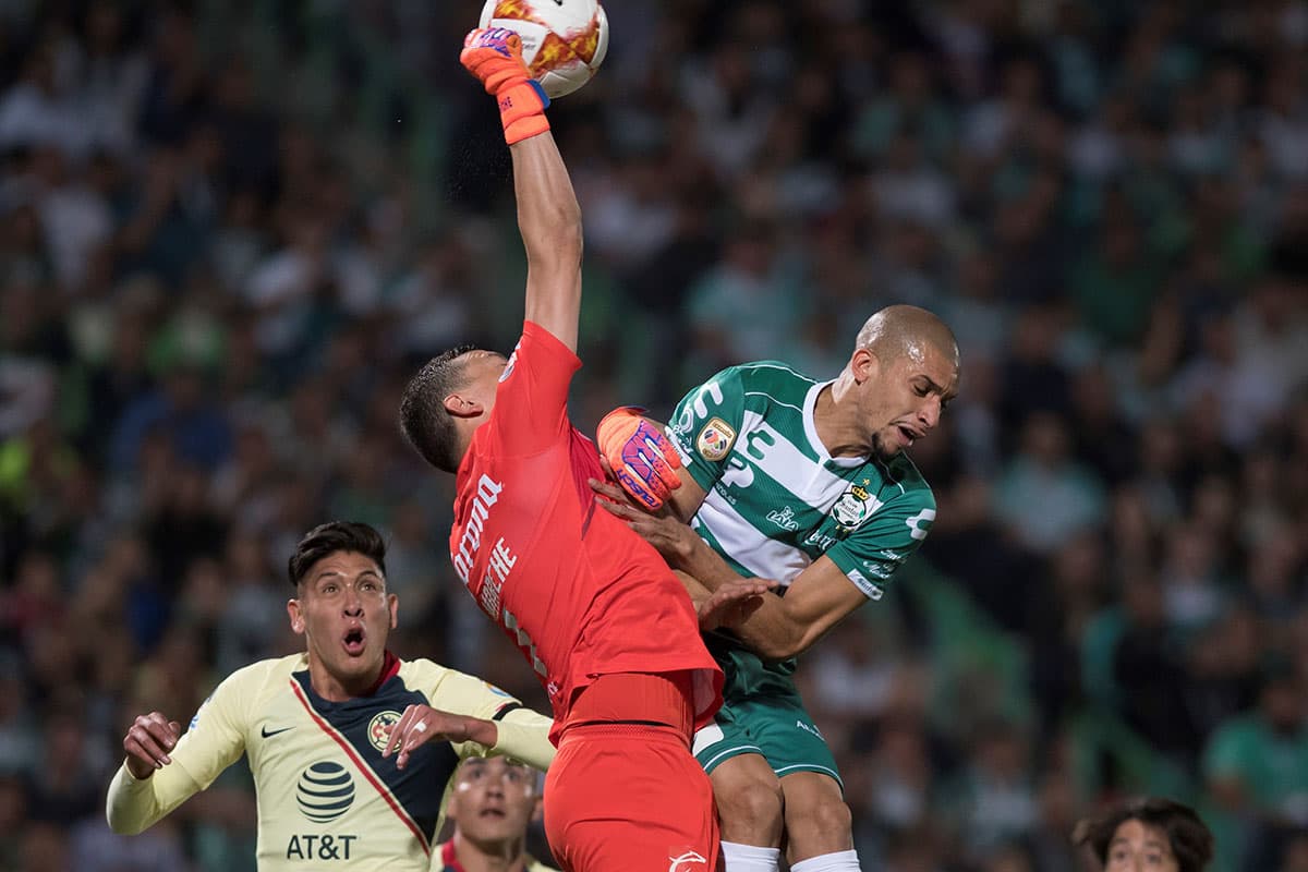 Una de las buenas intervenciones del arquero argentino de las Águilas, Agustín Marchesín, ante el brasileño de Santos Laguna, Matheus Dória (derecha).
