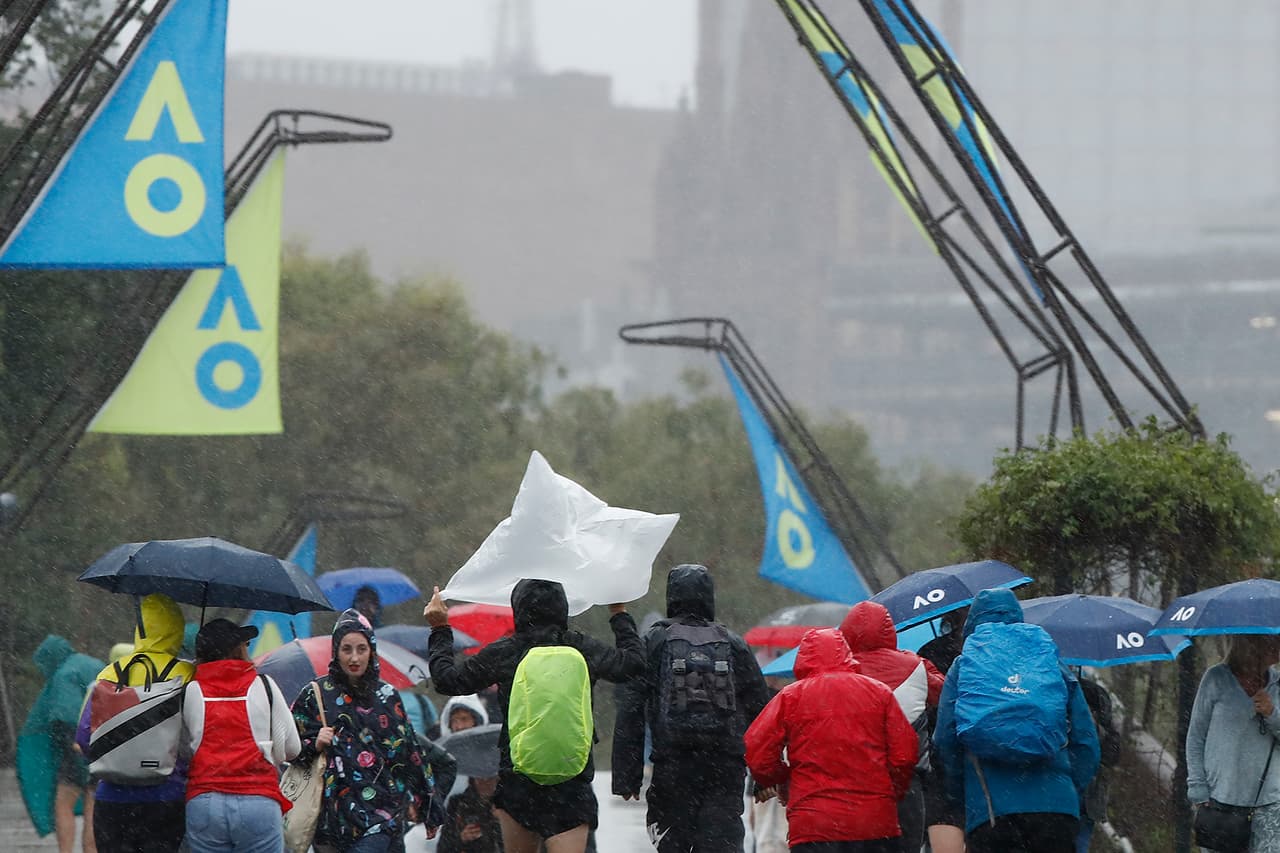 Aficionados caminando bajo la lluvia previo a los partidos del Australian Open.