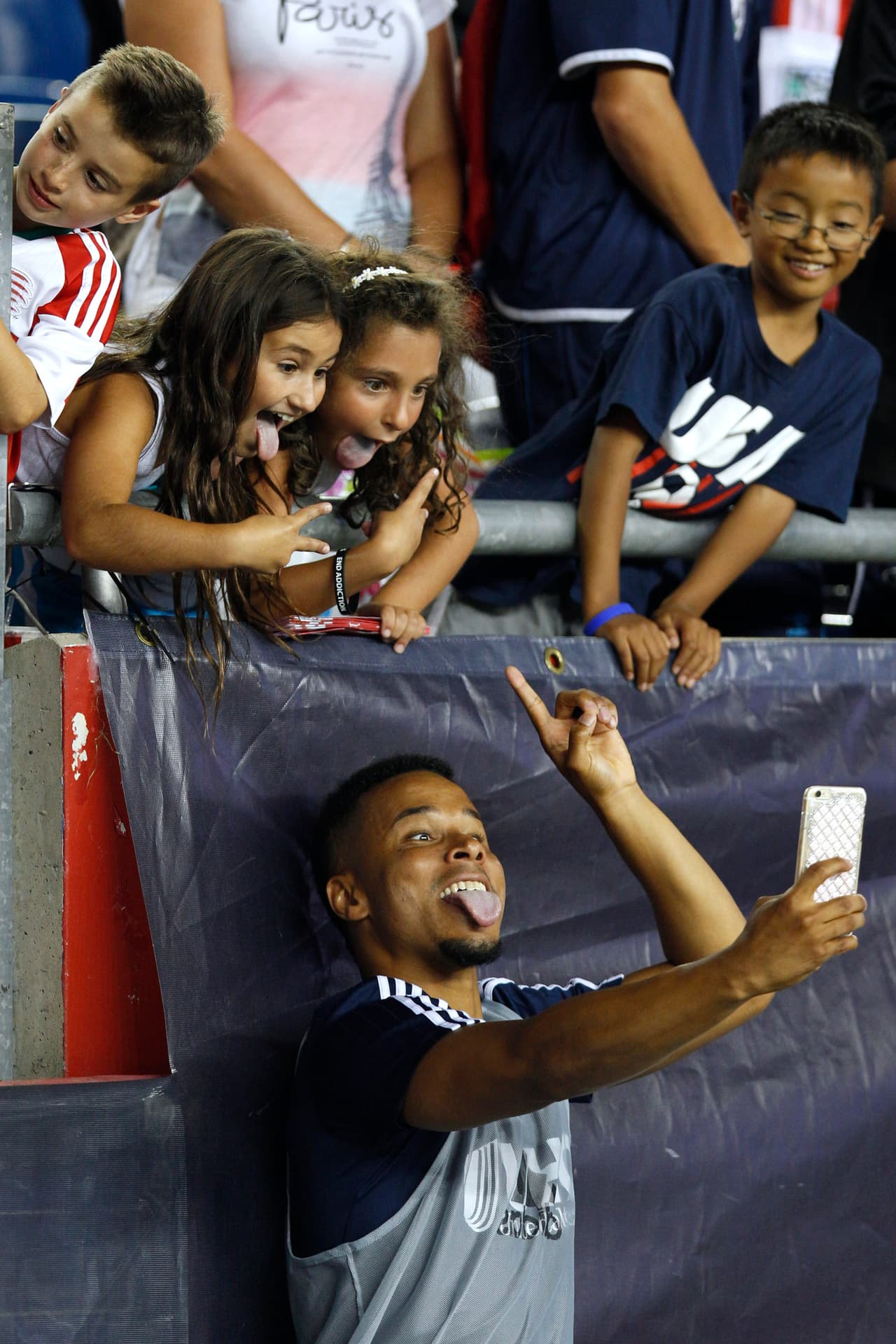 Charlie Davies, tras la victoria de New England Revolution, sobre Toronto FC, tomándose una selfie con dos niñas aficionadas.