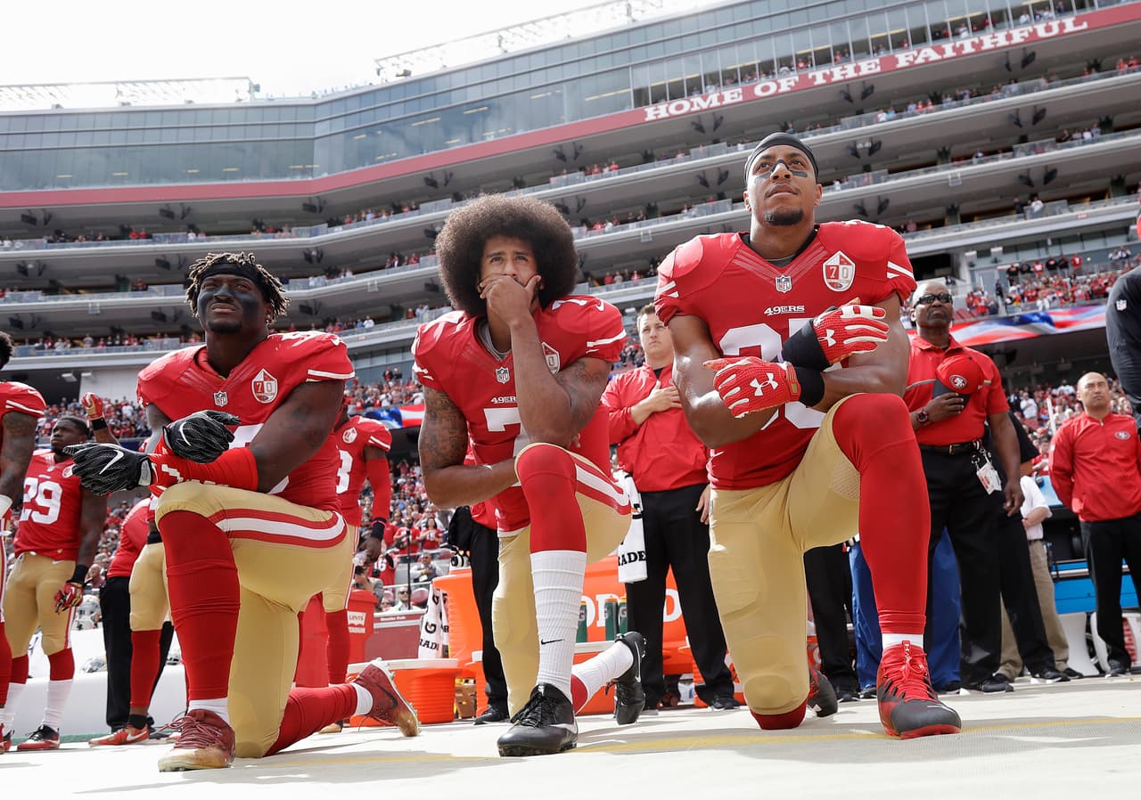 Eli Harold, Colin Kaepernick y Eric Reid nuevamente sobre una rodilla durante el himno de los EEUU como protesta por la injusticia racial en el país.