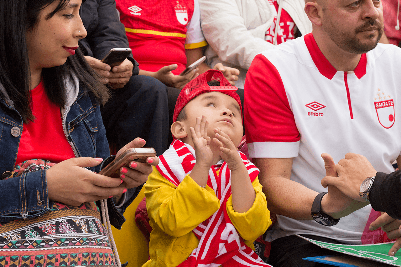 Camila (izquierda), madre de Juan Sebastián (centro), comparten la alegría del público cuando Santa Fe conecta jugadas de gol.