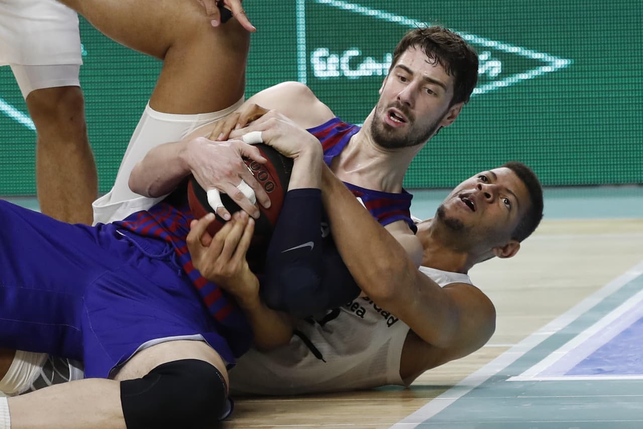 El pivot croata del FC Barcelona Lassa, Ante Tomic (izquierda), pelea un balón con el jugador caboverdiano del Real Madrid, Walter Tavares (en el piso).