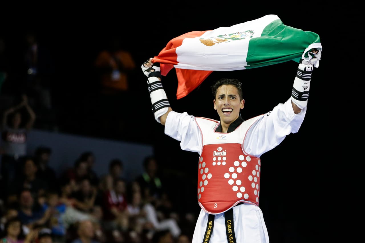 Mexico's Carlos Navarro celebrates after winning his men's -58kg gold medal taekwondo match against Dominican Republic's Luisito Pie at the Pan Am Games in Mississauga, Ontario, Sunday, July 19, 2015. (AP Photo/Felipe Dana)
