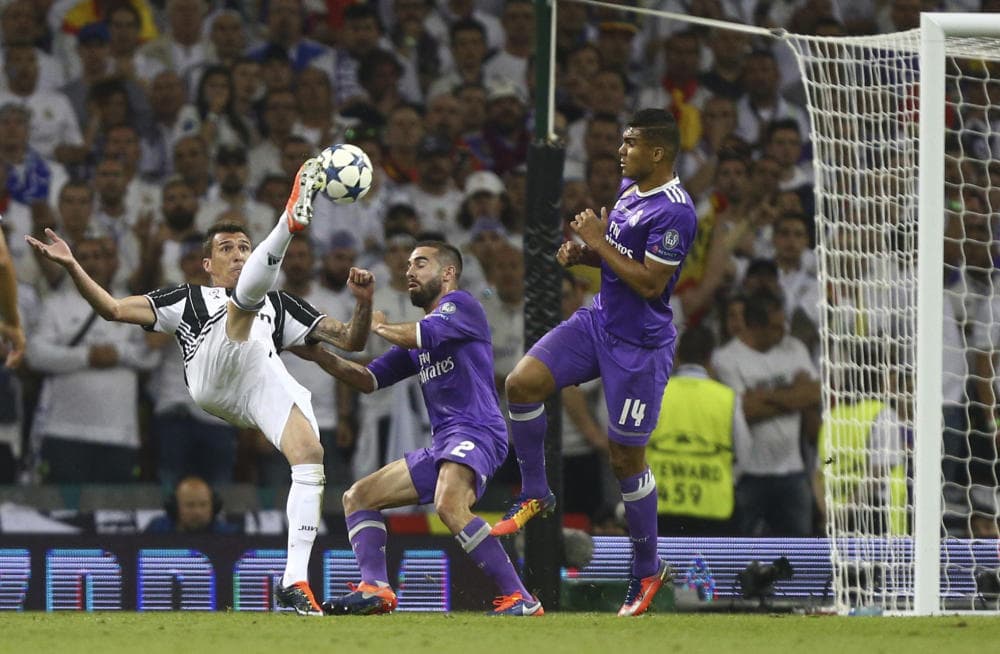 El jugador de la Juventus, Mario Mandzukic, izquierda, remata para anotar un gol contra Real Madrid en al final de la Liga de Campeones el sábado, 3 de junio de 2017, en Cardiff, Gales.