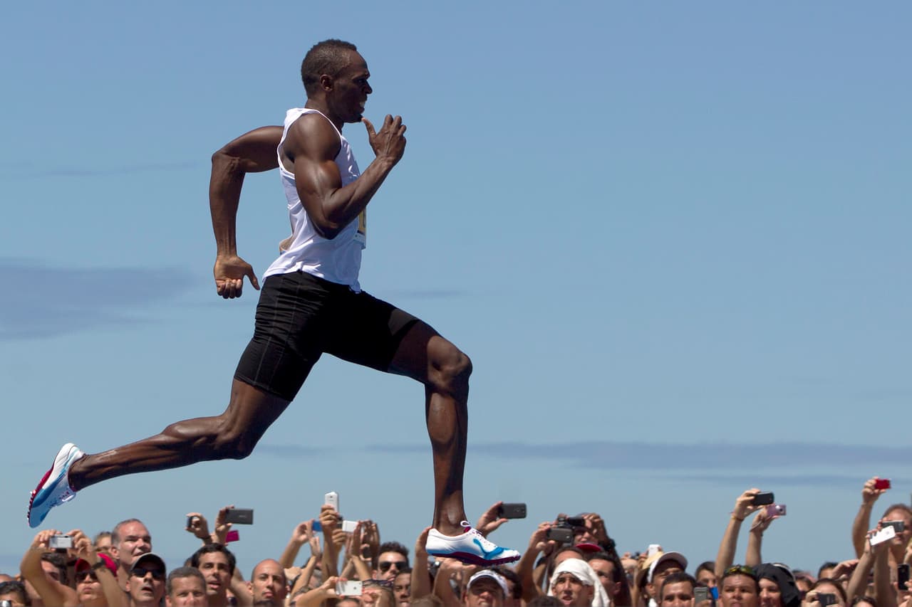 Jamaican Olympic gold medallist Usain Bolt runs to win the "Mano a Mano" Men's 150m challenge on Copacabana beach in Rio de Janeiro, Brazil, Sunday, March 31, 2013. Bolt defeated Antigua and Barbuda's Daniel Bailey, Ecuador's Alex Quinones and Brazil's Bruno Lins de Barros on a 150m track specially built at the famous beach. (AP Photo/Felipe Dana)