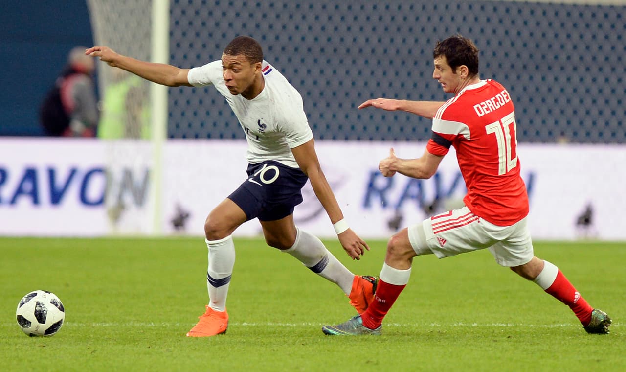 France's forward Kylian Mbappe (L) and Russia's midfielder Alan Dzagoev vie for the ball during an international friendly football match between Russia and France at the Saint Petersburg Stadium in Saint Petersburg on March 27, 2018. / AFP PHOTO / Olga MALTSEVA (Photo credit should read OLGA MALTSEVA/AFP/Getty Images)