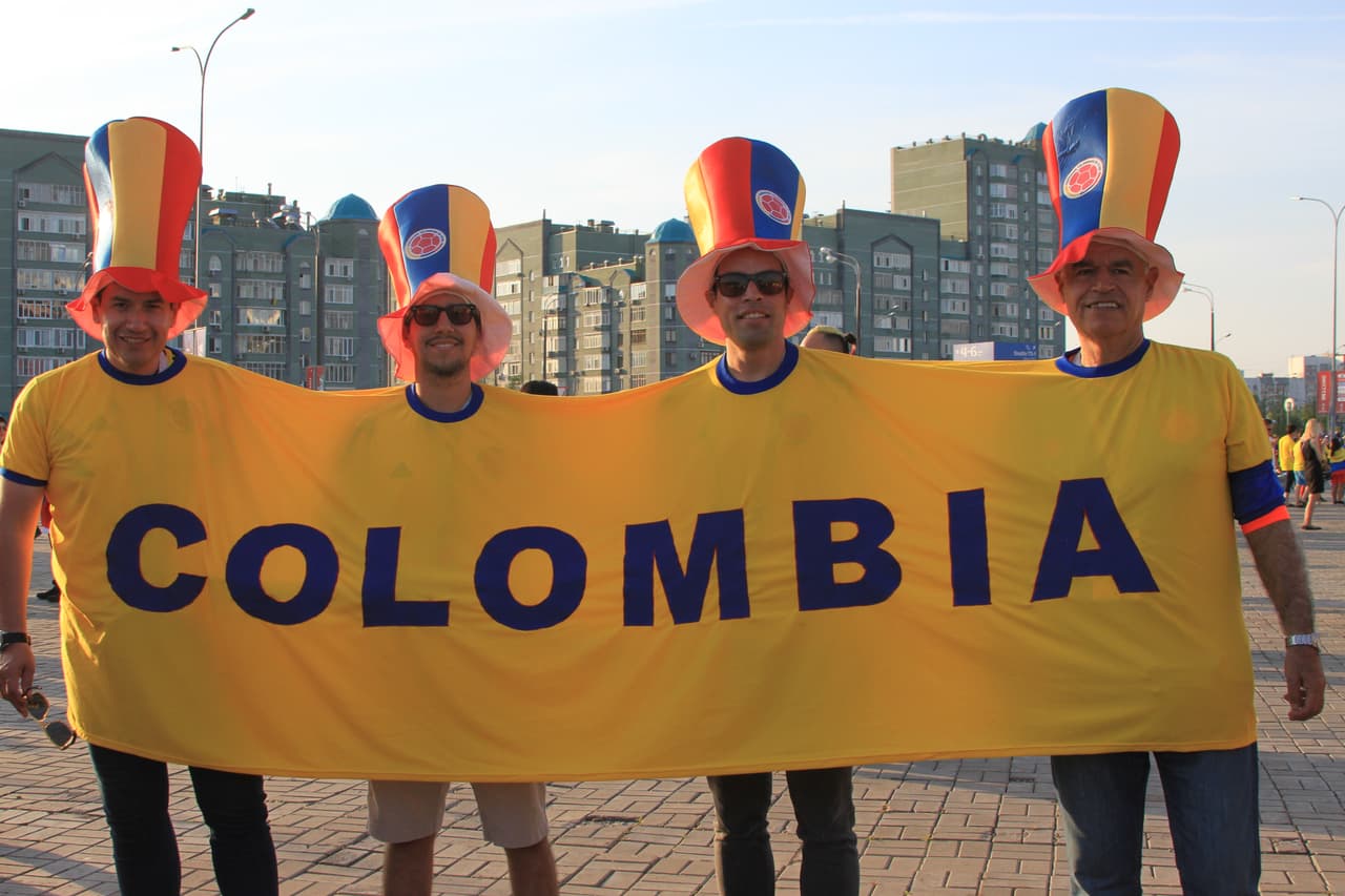 Cuatro colombianos unidos con una sola prenda apoyando a su selección.