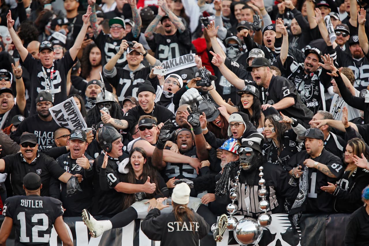 OAKLAND, CA - DECEMBER 7: Linebacker Sio Moore #55 of the Oakland Raiders jumps into arms of fans in the Black Hole after defeating the San Francisco 49ers on December 7, 2014 at O.co Coliseum in Oakland, California. The Raiders won 24-13. (Photo by Brian Bahr/Getty Images)
