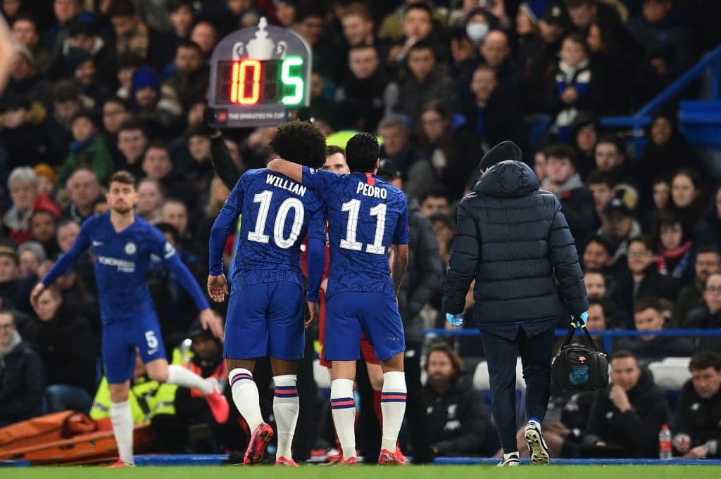 Chelsea's Spanish midfielder Pedro (R) hugs Chelsea's Brazilian midfielder Willian (C) as Willian leaves the pitch after being substituted off for Chelsea's Italian midfielder Jorginho during the English FA Cup fifth round football match between Chelsea and Liverpool at Stamford Bridge in London on March 3, 2020. (Photo by Glyn KIRK / AFP) / RESTRICTED TO EDITORIAL USE. No use with unauthorized audio, video, data, fixture lists, club/league logos or 'live' services. Online in-match use limited to 120 images. An additional 40 images may be used in extra time. No video emulation. Social media in-match use limited to 120 images. An additional 40 images may be used in extra time. No use in betting publications, games or single club/league/player publications. / (Photo by GLYN KIRK/AFP via Getty Images)
