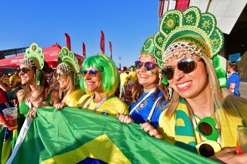 Brazilian fans sporting fancy hats and wig pose with a national flag outside the stadium before the Russia 2018 World Cup Group E football match between Serbia and Brazil at the Spartak Stadium in Moscow on June 27, 2018. (Photo by Mladen ANTONOV / AFP) (Photo credit should read MLADEN ANTONOV/AFP/Getty Images)